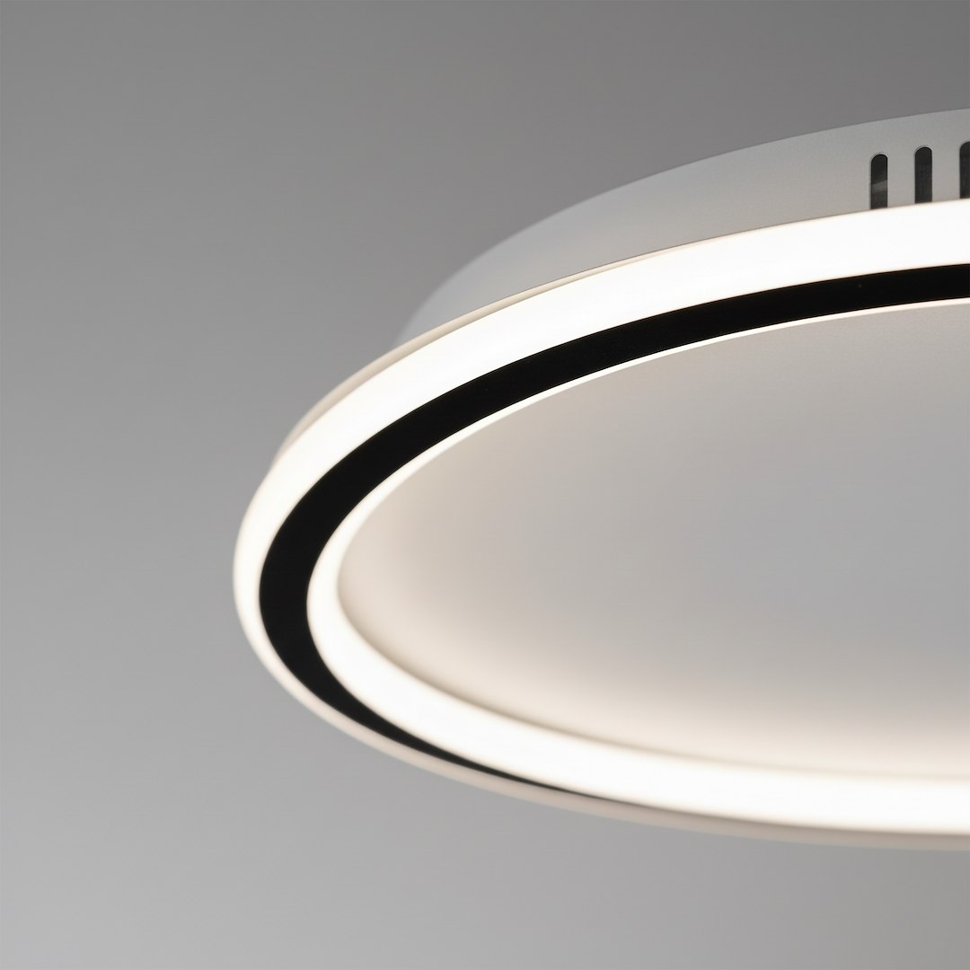 Cali Round lampa sufitowa LED 30W 4000K w kolorze czarnym i białym, z okrągłą płaską obudową. Widoczny czarny pierścień na zewnętrznej krawędzi oraz biała powierzchnia wewnętrzna. Ujęcie z góry, podkreślające kształt i detal wykończenia.