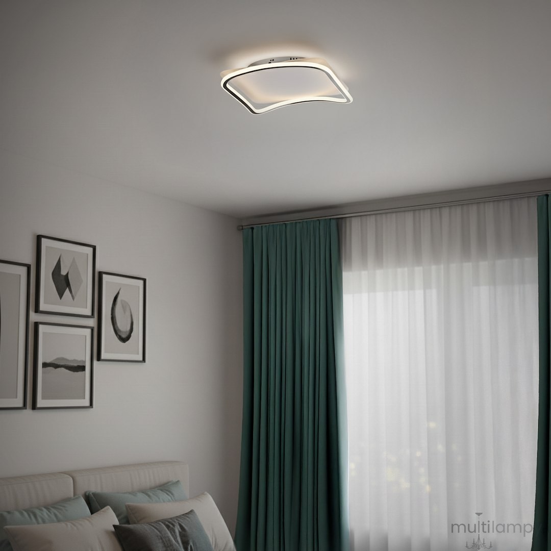 Cali Square lampa sufitowa LED 30W 4000K w kolorze czarnym i białym, z nowoczesnym, falistym kształtem. Zainstalowana na suficie w jasnym wnętrzu z zasłonami w odcieniu turkusu, obok ściany z obrazami.