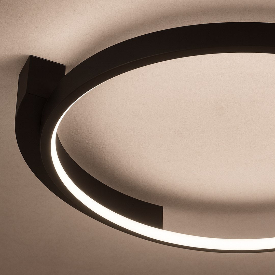 Czarna lampa sufitowa LED Luna, moc 18W, temperatura barwowa 4000K. Okrągła konstrukcja z subtelnym podświetleniem, zamontowana blisko sufitu. Widoczny detal w kształcie prostokątnego mocowania.