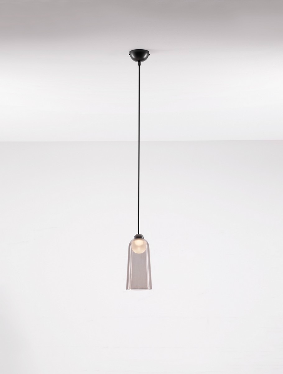 Czarna lampa wisząca Tavenco z jedną żarówką LED 5W, zawieszona na czarnym przewodzie. Szklany klosz o prostokątnym kształcie, z przezroczystego materiału, umieszczony na okrągłej podstawie.