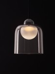Lampa wisząca Tavenco z pojedynczym źródłem LED 5W, w czarnej obudowie. Klosz z przezroczystego szkła o cylindrycznym kształcie, z białą kulą wewnątrz, zawieszona na czarnym przewodzie. Ujęcie frontalne.