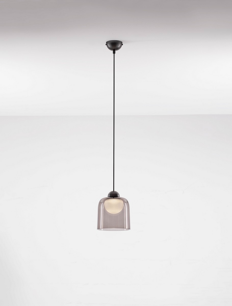 Czarna lampa wisząca Tavenco z jedną żarówką LED 5W. Szklany klosz o delikatnym, przezroczystym wykończeniu, zawieszony na cienkim, czarnym przewodzie. Lampa montowana do sufitu, w minimalistycznym stylu, idealna do nowoczesnych wnętrz.