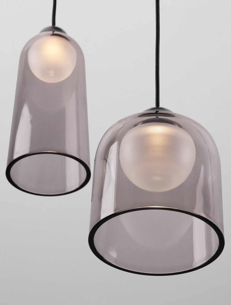 Lampa wisząca Tavenco z trzema kloszami w kolorze czarnym z przezroczystym szkłem, o okrągłym kształcie. Zawieszenie na czarnym przewodzie, z widocznym źródłem światła LED 15W w każdym kloszu. Produkt prezentowany na jasnym tle.