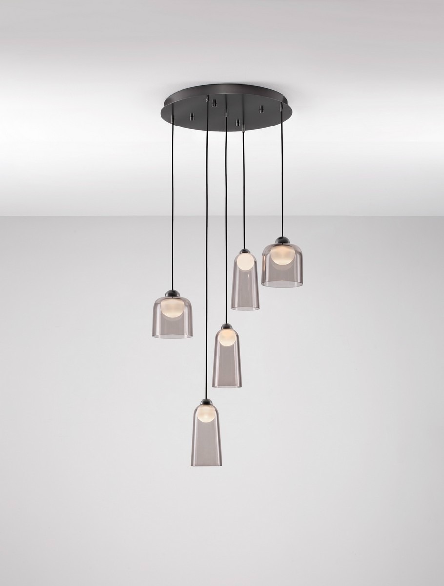 Lampa wisząca Tavenco z pięcioma kloszami LED, czarna, z przezroczystymi kloszami, zawieszona na cienkich linkach. Klosze mają okrągłe źródła światła, przymocowane do okrągłej podstawy sufitowej. Tło gładkie, jasne.