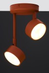 Lampa wisząca Nemo 2xGX53 w kolorze ceglastym z dwoma okrągłymi kloszami. Klosze są zamocowane na metalowych prętach, emitując ciepłe światło. Ujęcie z boku, na jednolitym ciemnym tle, ukazuje detale konstrukcji i fakturę materiału.