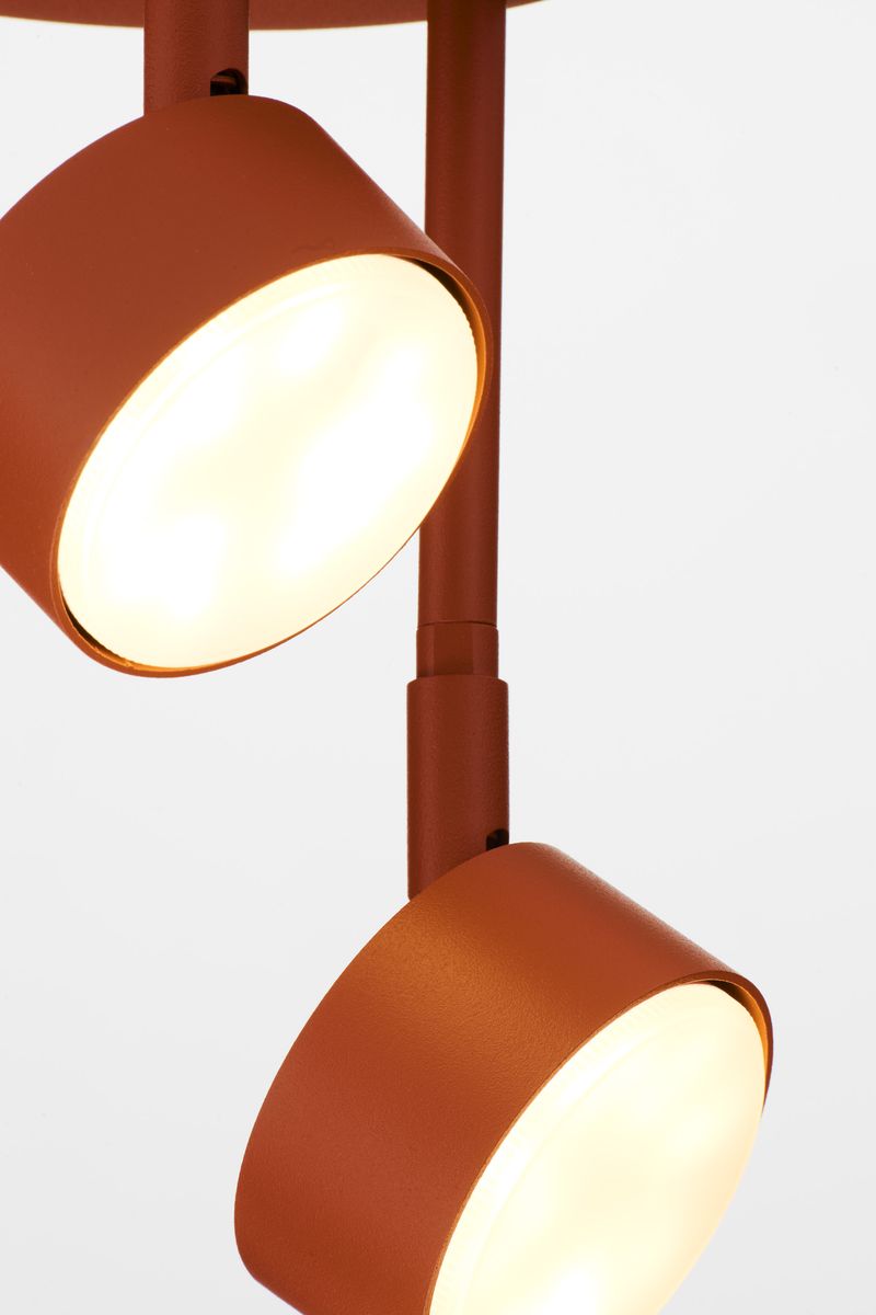 Lampa wisząca Nemo w ceglanej kolorystyce z trzema okrągłymi kloszami GX53. Klosze zawieszone na prostych, metalowych ramionach. Zbliżenie na detale konstrukcji oraz źródła światła. Tło proste, białe.