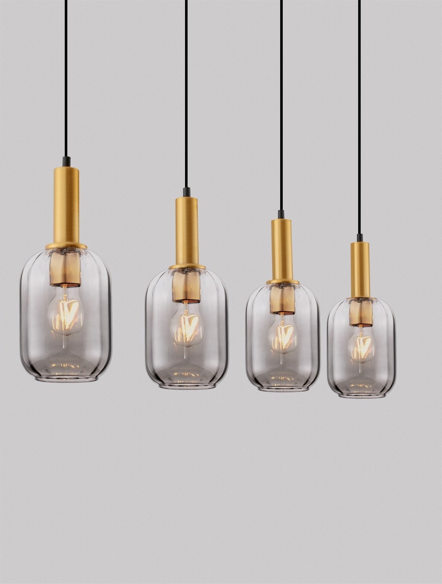 Lampa wisząca Querisa 4xE27 w złotym kolorze z przezroczystymi kloszami. Cztery klosze o różnych wysokościach, zawieszone na czarnych przewodach, tworzą nowoczesną aranżację. Tło w neutralnym odcieniu szarości.