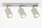 Lampa sufitowa Zoom z trzema spotami GU10 w odcieniu szarym beżowym. Ułożona poziomo, z cylindrycznymi kloszami skierowanymi w dół. Metalowa konstrukcja, minimalistyczny design, widoczne ciepłe światło z żarówek.