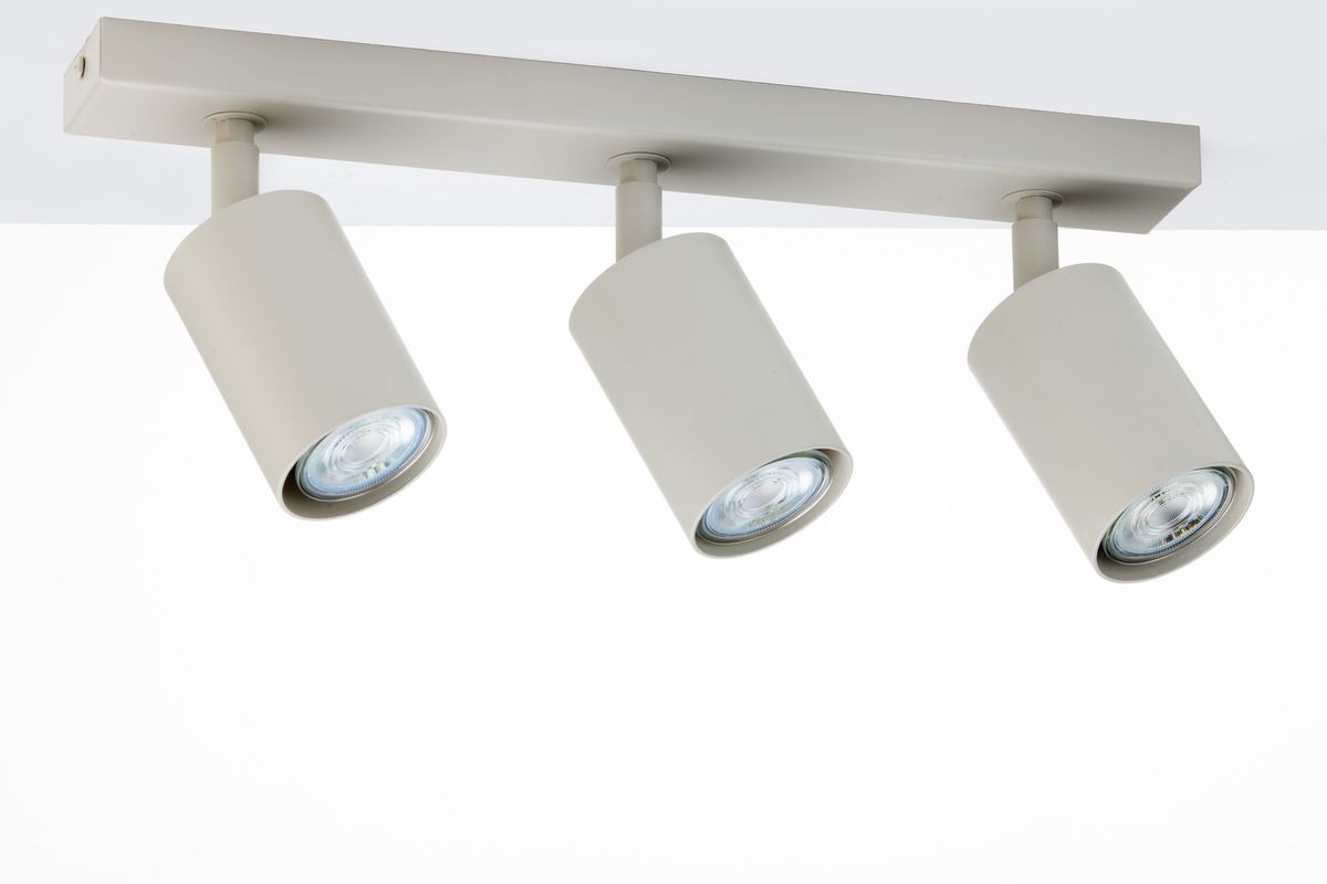 Lampa sufitowa Zoom w kolorze szarym beżowym z trzema regulowanymi reflektorami GU10, zamontowana na prostokątnej podstawie. Reflektory mają cylindryczny kształt i emitują intensywne światło, idealna do oświetlenia wnętrz.