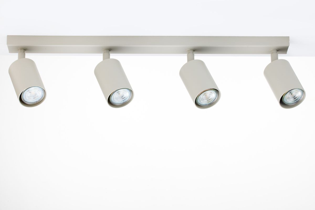 Lampa sufitowa Zoom z czterema punktami świetlnymi GU10 w kolorze szarym beżowym. Ujęcie z przodu, lampy zamocowane na prostokątnej podstawie, cylindryczne klosze skierowane w dół, idealna do oświetlenia wnętrz.