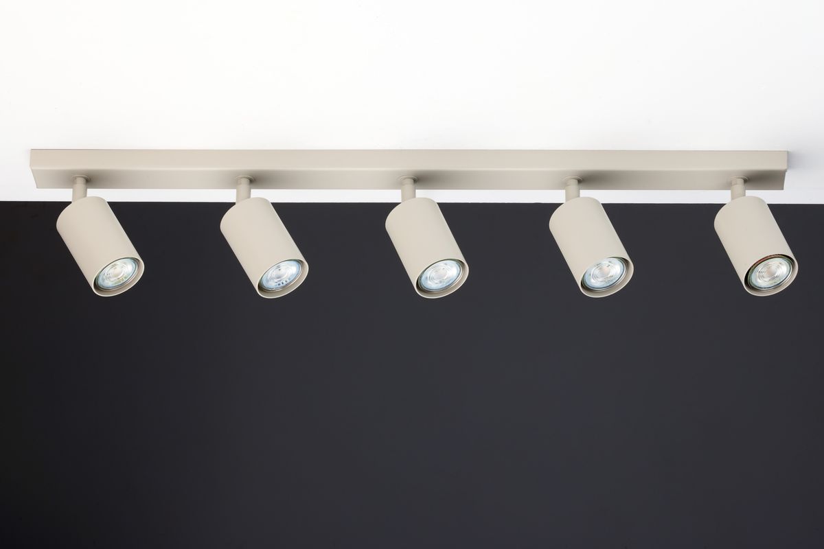 Lampa sufitowa Zoom w kolorze szarym beżowym z pięcioma punktami świetlnymi GU10, montowana na prostokątnej listwie. Ujęcie frontalne, pokazujące równomiernie rozmieszczone reflektory skierowane w dół, na tle ciemnej ściany.
