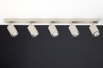 Lampa sufitowa Zoom w kolorze szarym beżowym z pięcioma punktami świetlnymi GU10, montowana na prostokątnej listwie. Ujęcie frontalne, pokazujące równomiernie rozmieszczone reflektory skierowane w dół, na tle ciemnej ściany.