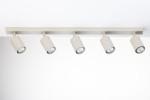 Lampa sufitowa typu spot w kolorze szarym beżowym z pięcioma źródłami światła GU10, zamontowana na prostokątnej, płaskiej podstawie. Klosze mają cylindryczny kształt, skierowane w różnych kierunkach. Tło zdjęcia jest jasne i jednolite.