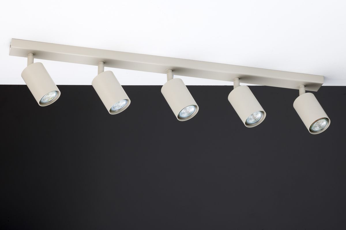Lampa sufitowa Zoom w kolorze szarym beż, z pięcioma punktami świetlnymi GU10. Ujęcie z boku, pokazujące cylindryczne klosze zamocowane na prostokątnej listwie. Tło czarne, co podkreśla kolor lampy.
