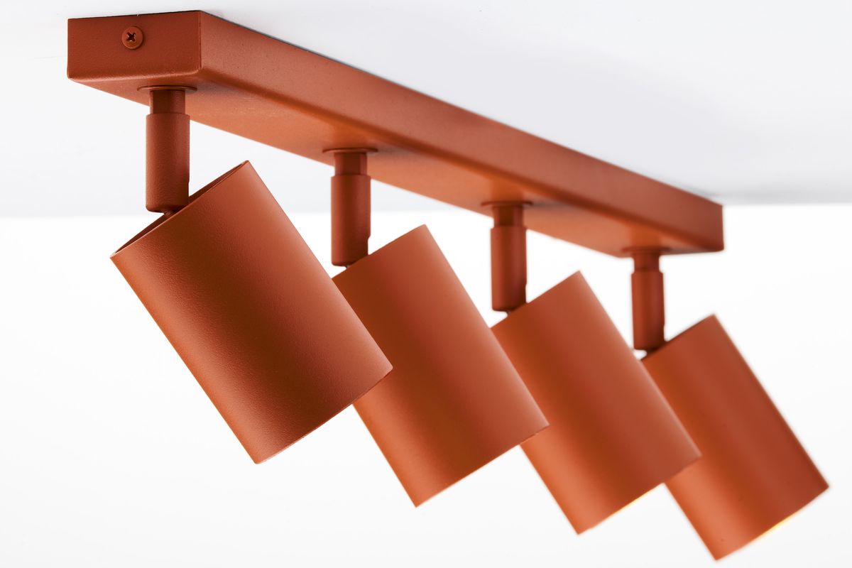 Ceglany sufitowy spot z czterema reflektorami GU10, zamontowany na prostokątnej podstawie. Reflektory mają cylindryczny kształt i są ustawione pod różnymi kątami, co umożliwia kierowanie światła. Tło białe, minimalistyczne.