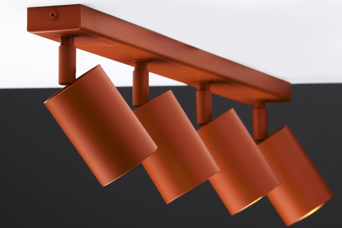 Ceglany sufitowy spot z czterema lampami GU10, umieszczony na prostokątnej podstawie. Lampy mają cylindryczny kształt, matową powierzchnię i są ustawione pod różnymi kątami, co umożliwia kierunkowe oświetlenie.