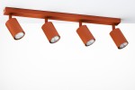 Ceglany sufitowy spot z czterema lampami GU10, w prostokątnej metalowej obudowie. Lampy mają cylindryczny kształt i są umieszczone na wsporniku. Ujęcie frontalne, jasne tło podkreśla kolor lampy.