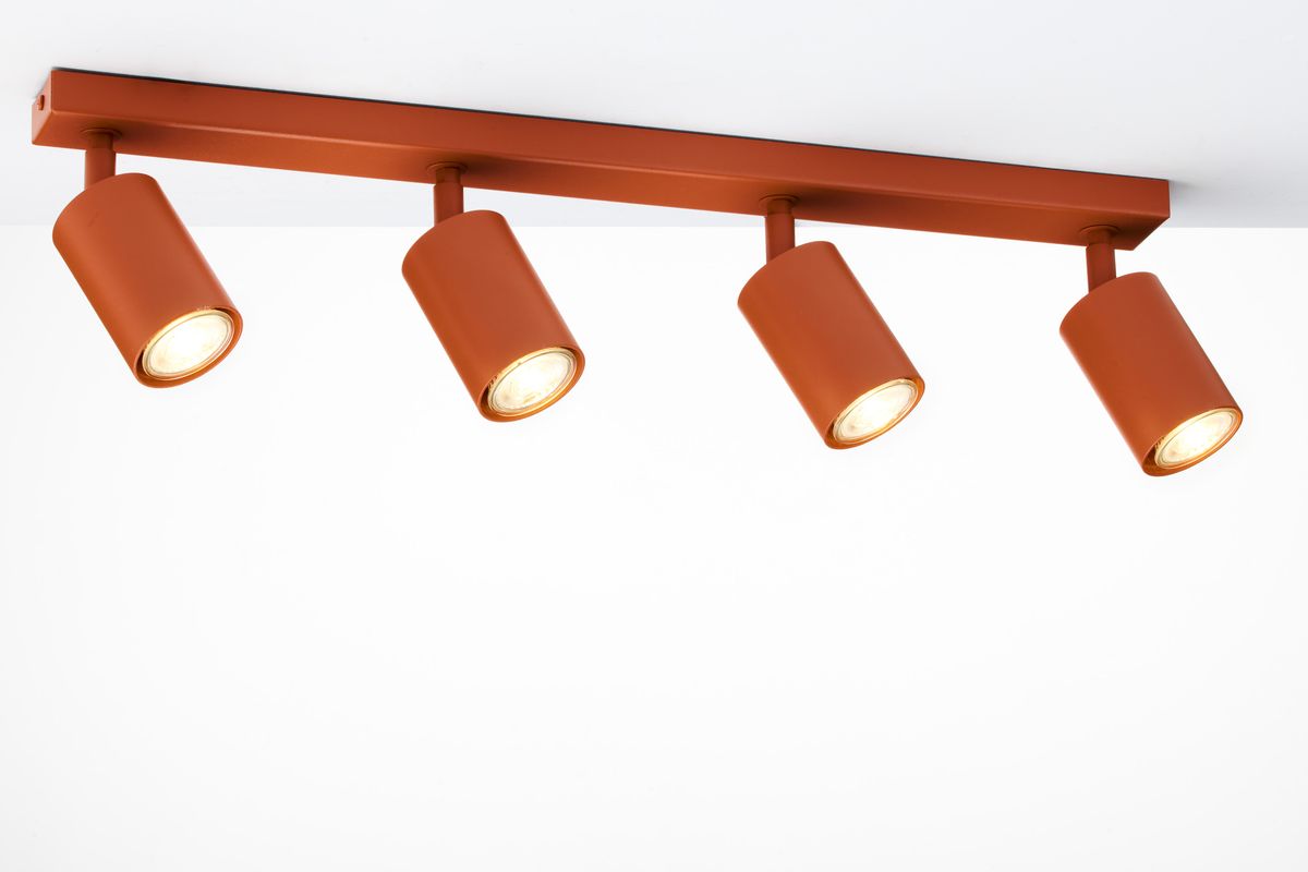 Lampa sufitowa Zoom w kolorze ceglastym z czterema reflektorami GU10. Ujęcie z góry, prezentujące prostokątną podstawę oraz cylindryczne klosze, skierowane w różnych kierunkach. Na białym tle, minimalizm podkreślający nowoczesny design.