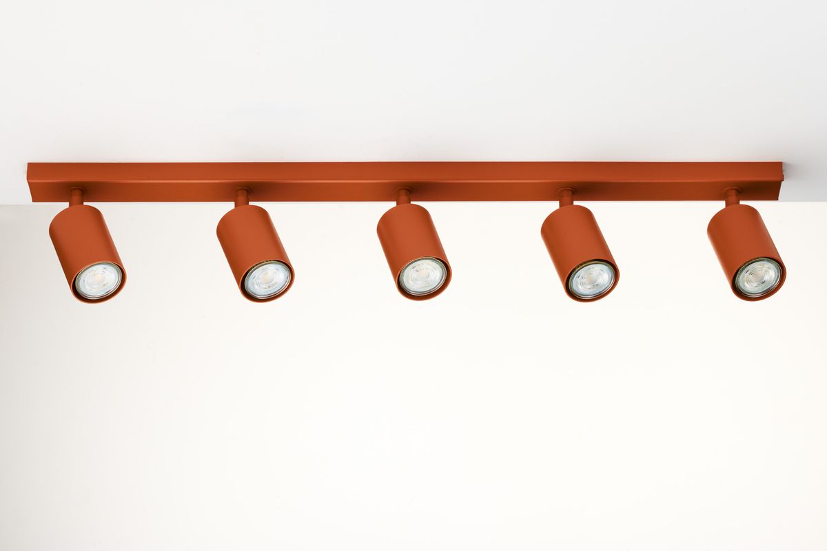 Lampa sufitowa Zoom z pięcioma reflektorami GU10 w ceglanym kolorze. Ułożona poziomo, z widocznymi cylindrycznymi kloszami, zamocowana na prostokątnej ramie. Idealna do oświetlenia wnętrz.