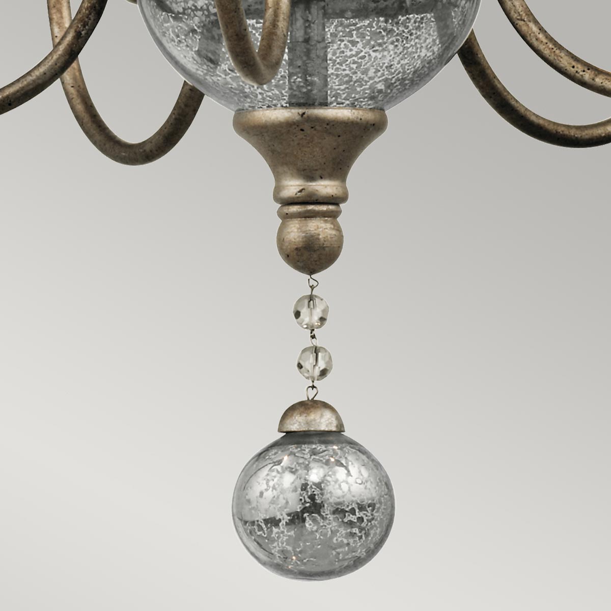 Lampa wisząca Rosalie S w kolorze starego jasnego złota, z pięcioma gniazdami E14. Zawiera dekoracyjny element w postaci szklanej kulki z efektem srebrzenia oraz kryształowe zdobienia. Ujęcie z dołu, pokazujące detale.