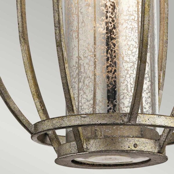 Lampa wisząca Rosalie w kolorze starego jasnego złota, z metalową konstrukcją i szklanym kloszem o dekoracyjnej fakturze. Klosz cylindryczny, umieszczony w widoku z bliska, eksponuje detal struktury szkła. Używa żarówki E27.