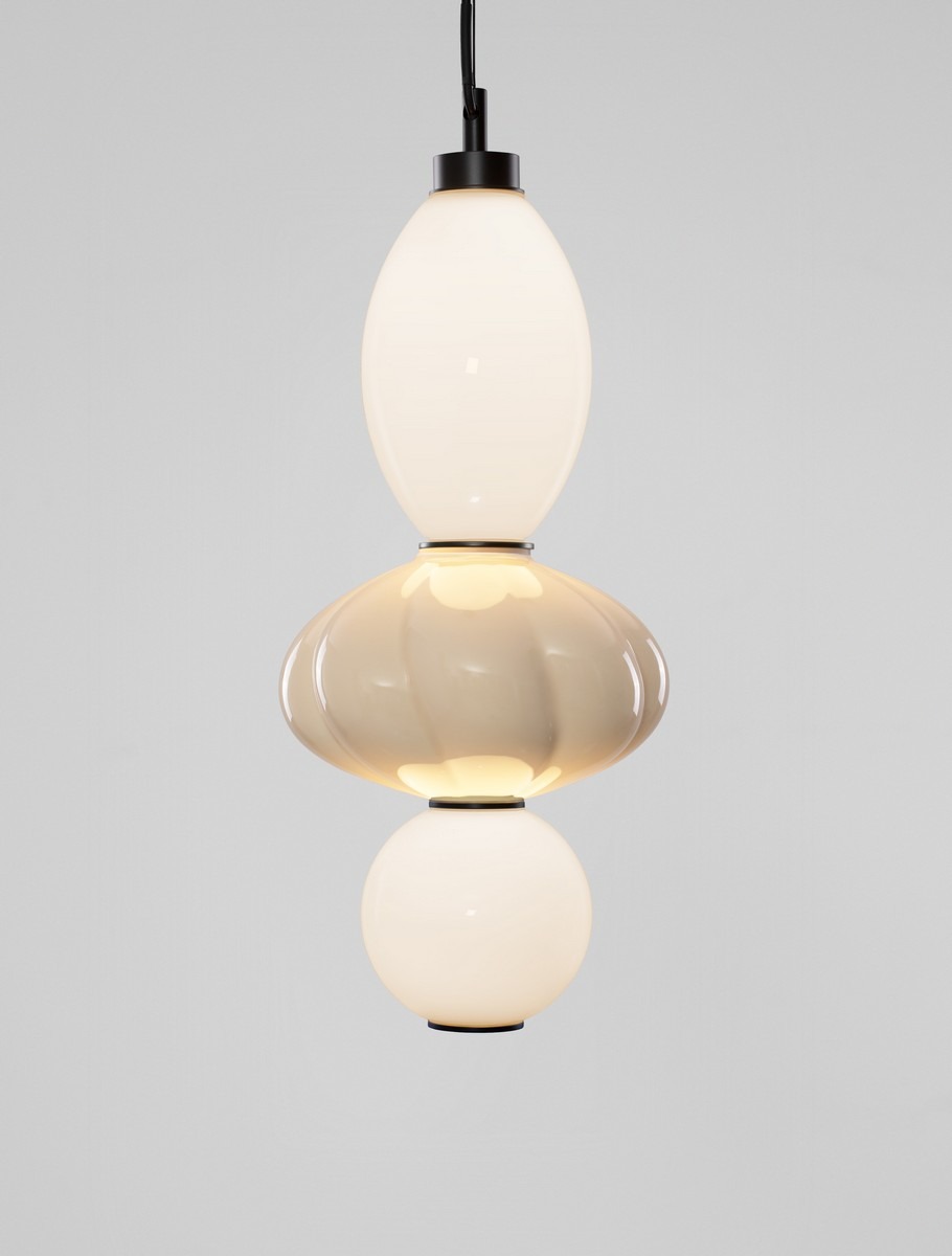 Lampa wisząca Casurno z jedną żarówką LED 18W, składająca się z trzech kulistych elementów w odcieniach bieli i beżu, z czarnym mocowaniem. Powieszona na czarnym przewodzie, z gładką, błyszczącą powierzchnią. Tło jasne, minimalistyczne.