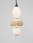 Lampa wisząca Casurno z jedną żarówką LED 18W, składająca się z trzech kulistych elementów w odcieniach bieli i beżu, z czarnym mocowaniem. Powieszona na czarnym przewodzie, z gładką, błyszczącą powierzchnią. Tło jasne, minimalistyczne.