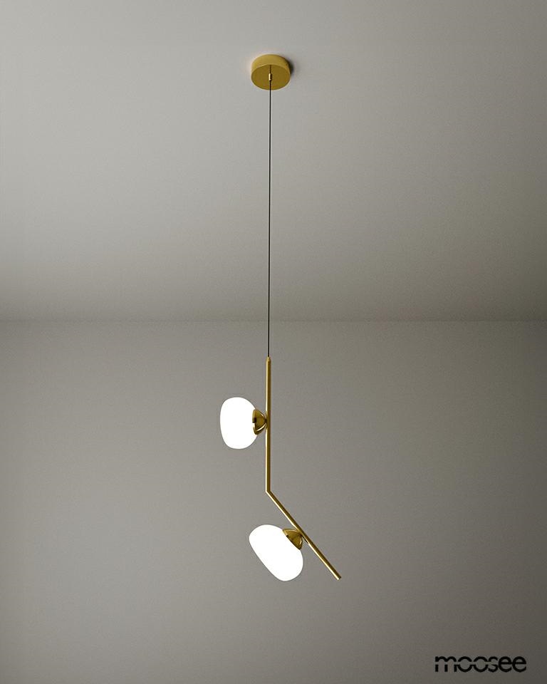 Lampa wisząca Rugia 2xG9 w kolorze złotym, z dwoma okrągłymi kloszami w białym kolorze. Ujęcie z góry, produkt zawieszony na cienkim przewodzie, prosty design, montowany na suficie. Tło w odcieniach szarości.