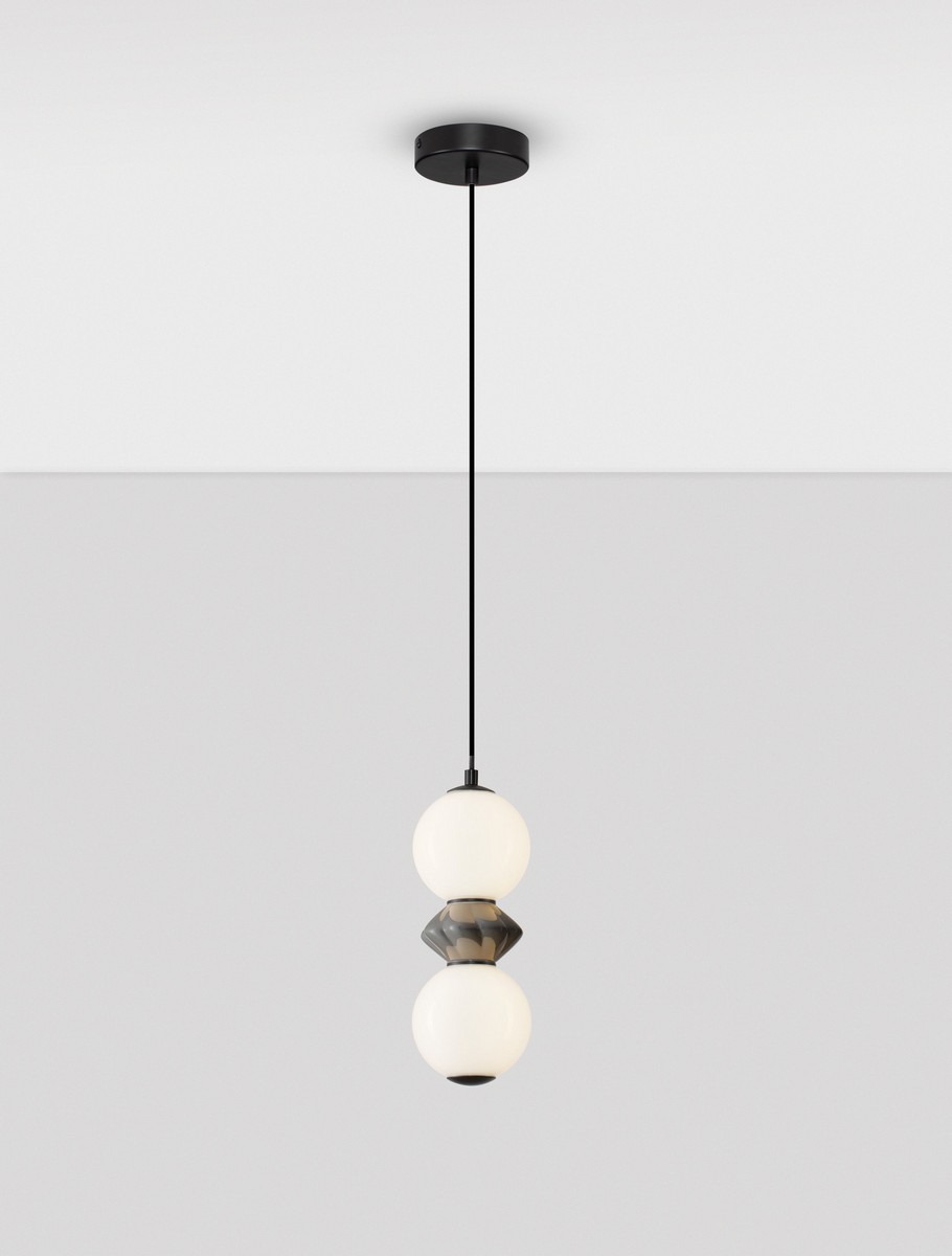 Lampa wisząca Monreta, czarna i szara, z jednym źródłem LED 10W. Składa się z dwóch okrągłych kloszy w białym kolorze, z dekoracyjnym elementem w kształcie diamentu. Zawieszona na cienkim, czarnym przewodzie.