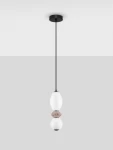 Lampa wisząca Monreta z jednym źródłem LED 12W. Posiada czarną oprawę oraz elementy szklane w białym i brązowym kolorze, zawieszona na cienkim czarnym kablu. Ujęcie frontalne, na jednolitym jasnoszarym tle.