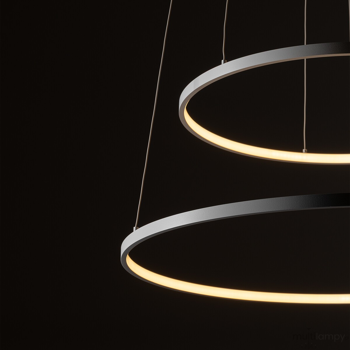 Lampa wisząca LED Circolo D60 w kolorze białym, składająca się z dwóch okrągłych pierścieni. Górny ma matowe wykończenie, dolny emituje ciepłe światło (3000K). Zawieszona na cienkich linkach, znajduje się na ciemnym tle.