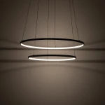 Lampa wisząca LED Circolo D60 o mocy 67W i barwie światła 3000K, w kolorze czarnym. Składa się z dwóch metalowych pierścieni, zawieszonych na cienkich linkach, rzucających delikatne cienie na ścianę.