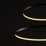 Lampa wisząca LED Circolo D60 o mocy 67W, w kolorze czarnym, z dwoma okrągłymi pierścieniami emitującymi ciepłe światło (3000K). Ujęcie z góry, detale krawędzi lampy na ciemnym tle, zawieszona na cienkich linach.