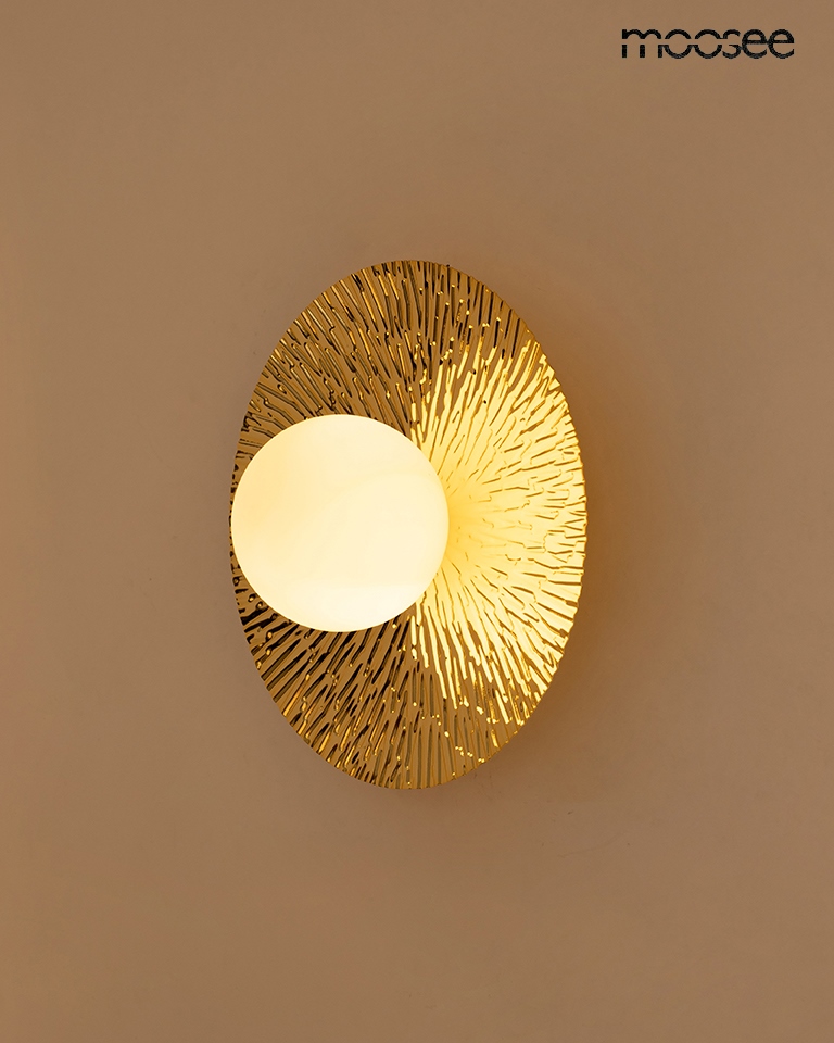 Kinkiet Soul 20 w kolorze złotym, z okrągłym kloszem w białym kolorze, o efektownej strukturze na tle. Zawieszony na ścianie, emituje ciepłe światło, idealny do nowoczesnych wnętrz. Wymiary: średnica około 30 cm.