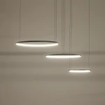 Lampa wisząca LED Circolo 85W, kolor czarny, z trzema okrągłymi kloszami zawieszonymi na cienkich linkach. Klosze emitują ciepłe światło 3000K, zawieszone na różnej wysokości, na jednolitym tle.