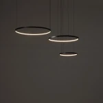 Lampa wisząca LED Circolo 85W 3000K w kolorze czarnym, składająca się z trzech okrągłych pierścieni o różnej średnicy, zawieszonych na cienkich linkach. Delikatne światło LED otacza pierścienie, tworząc nowoczesny efekt wizualny.