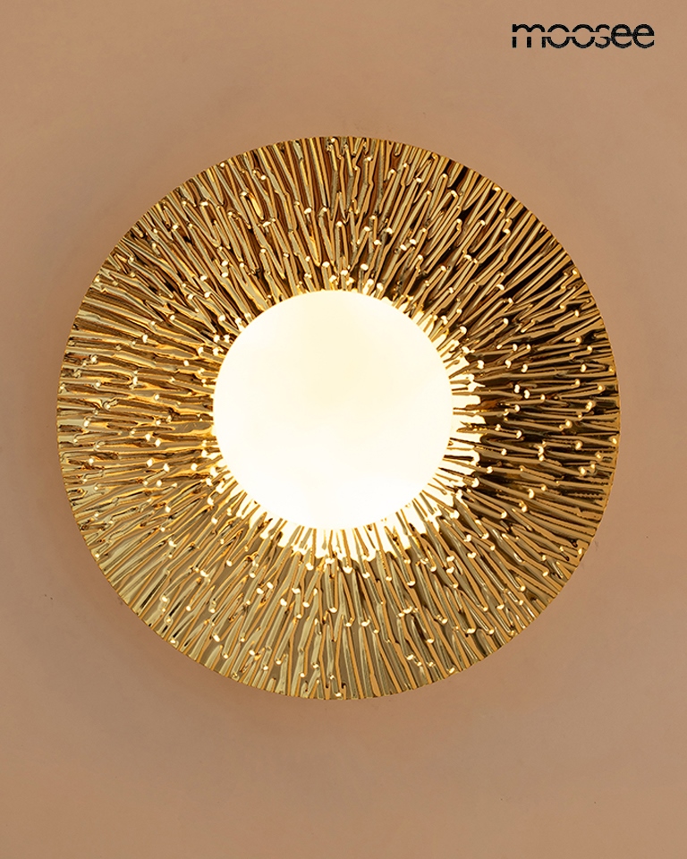 Kinkiet Soul 30 w kolorze złotym, z okrągłą podstawą i teksturowanym wykończeniem. Źródło światła G9 umieszczone w centralnej części, otoczone dekoracyjnym, wypukłym wzorem. Produkt zamontowany na ścianie, widok frontalny.