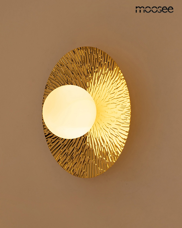 Kinkiet Soul 30 w kolorze złotym, o okrągłym kształcie z dekoracyjną teksturą. Centralna, mleczna kula źródła światła otoczona jest złotą ramką z wypukłymi, promienistymi wzorami. Montowany na ścianie, idealny do nowoczesnych wnętrz.