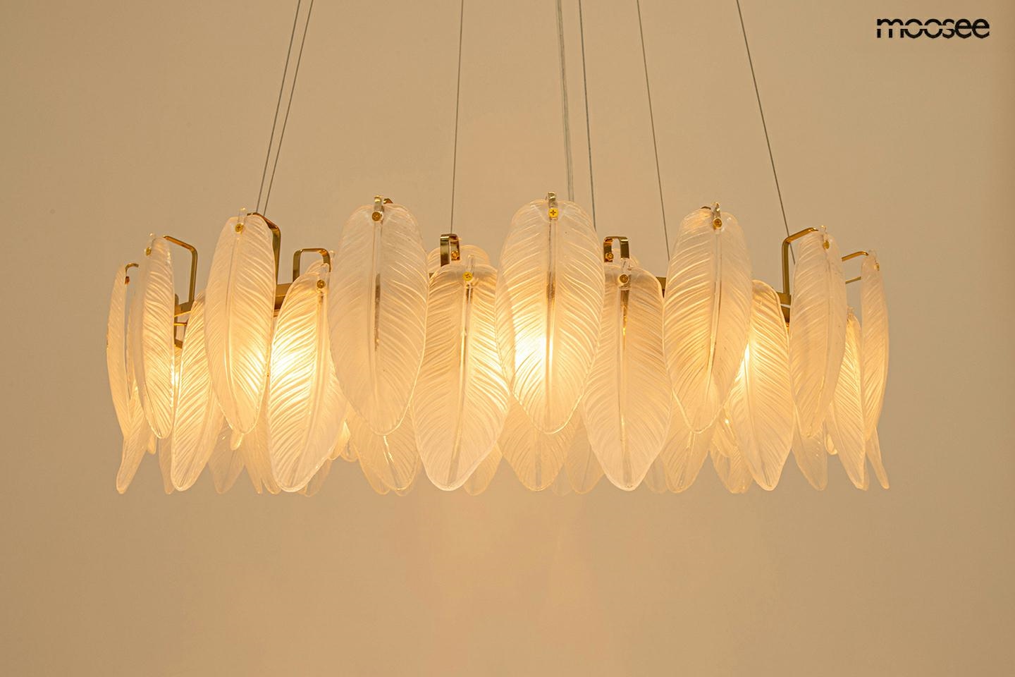 Lampa wisząca Roch 100 o złotej konstrukcji, z 12 źródłami światła E14, zdobiona przezroczystymi, teksturowanymi kloszami w kształcie liści. Ujęcie z góry, lampa zawieszona na cienkich linkach, na jasnym tle.