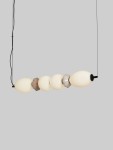 Lampa wisząca Monreta z jednym źródłem LED 28W, czarna z multikolorowymi kloszami w kształcie kul, zawieszona na cienkim czarnym przewodzie. Klosze w odcieniach białym i szarym, zamontowana w pozycji poziomej. Tło szare.