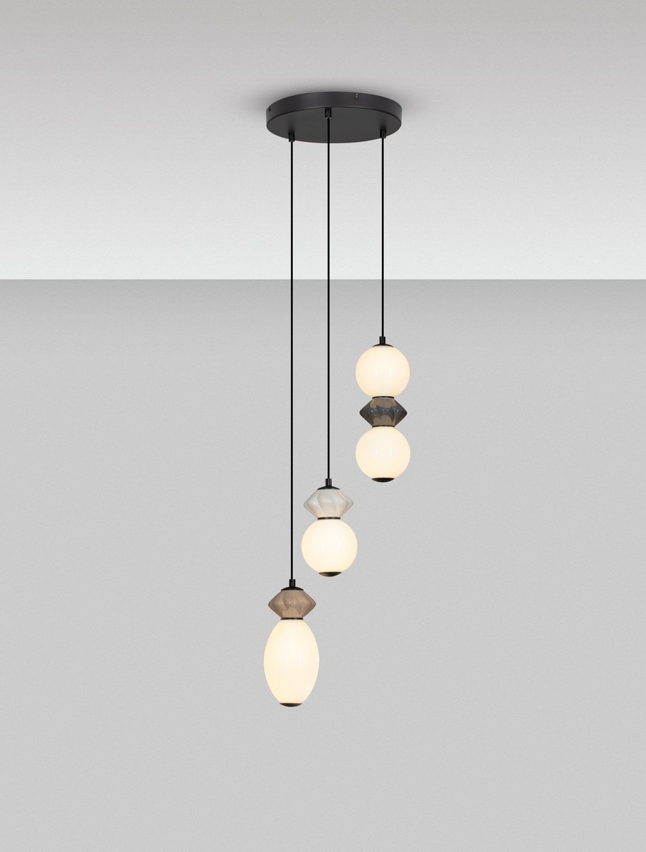 Lampa wisząca Monreta z trzema źródłami światła LED 20W w kolorze czarnym. Składa się z wiszących kulistych kloszy w różnych odcieniach (białym, szarym i przezroczystym), zawieszonych na czarnych linkach. Montaż sufitowy.
