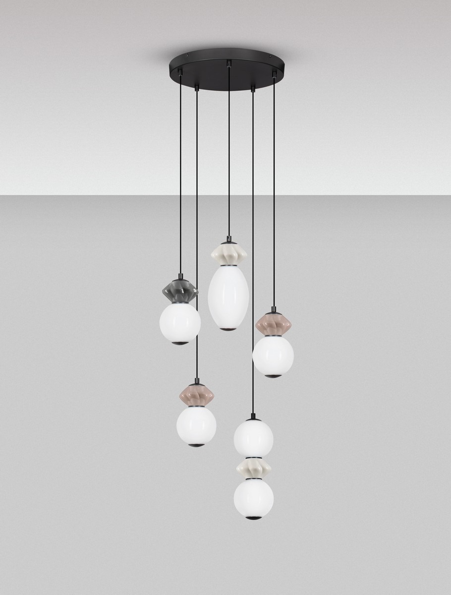 Lampa wisząca Monreta z pięcioma źródłami LED, czarna z multikolorowymi kloszami. Kształty kloszy są owalne i okrągłe, zawieszone na cienkich linkach. Klosze w kolorach białym, szarym i brązowym, zamontowane na okrągłej podstawie sufitowej.