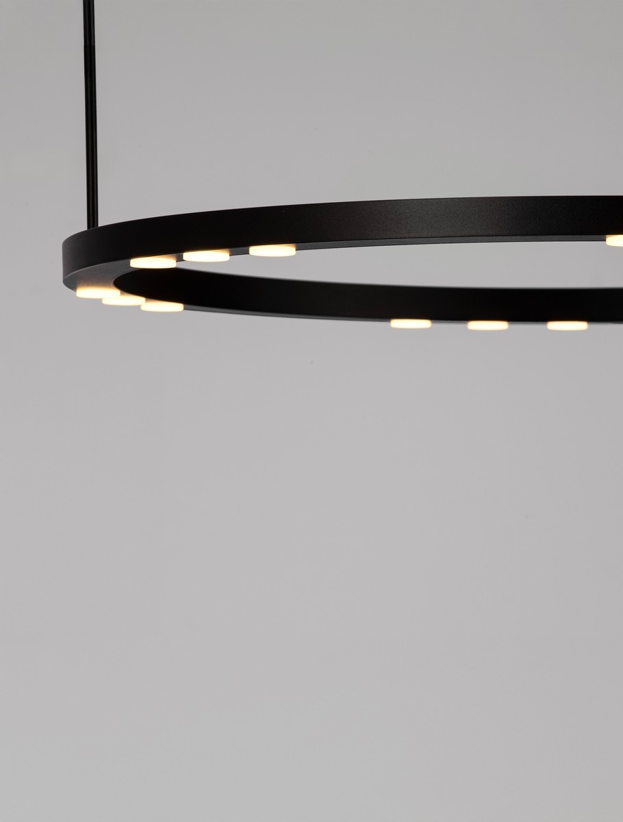 Czarna lampa wisząca Carenso z jedną diodą LED 34W, o okrągłej konstrukcji, z widocznymi punktami świetlnymi na zewnętrznej krawędzi. Ujęcie z góry, podkreślające minimalistyczny design. Tło szare, proste.