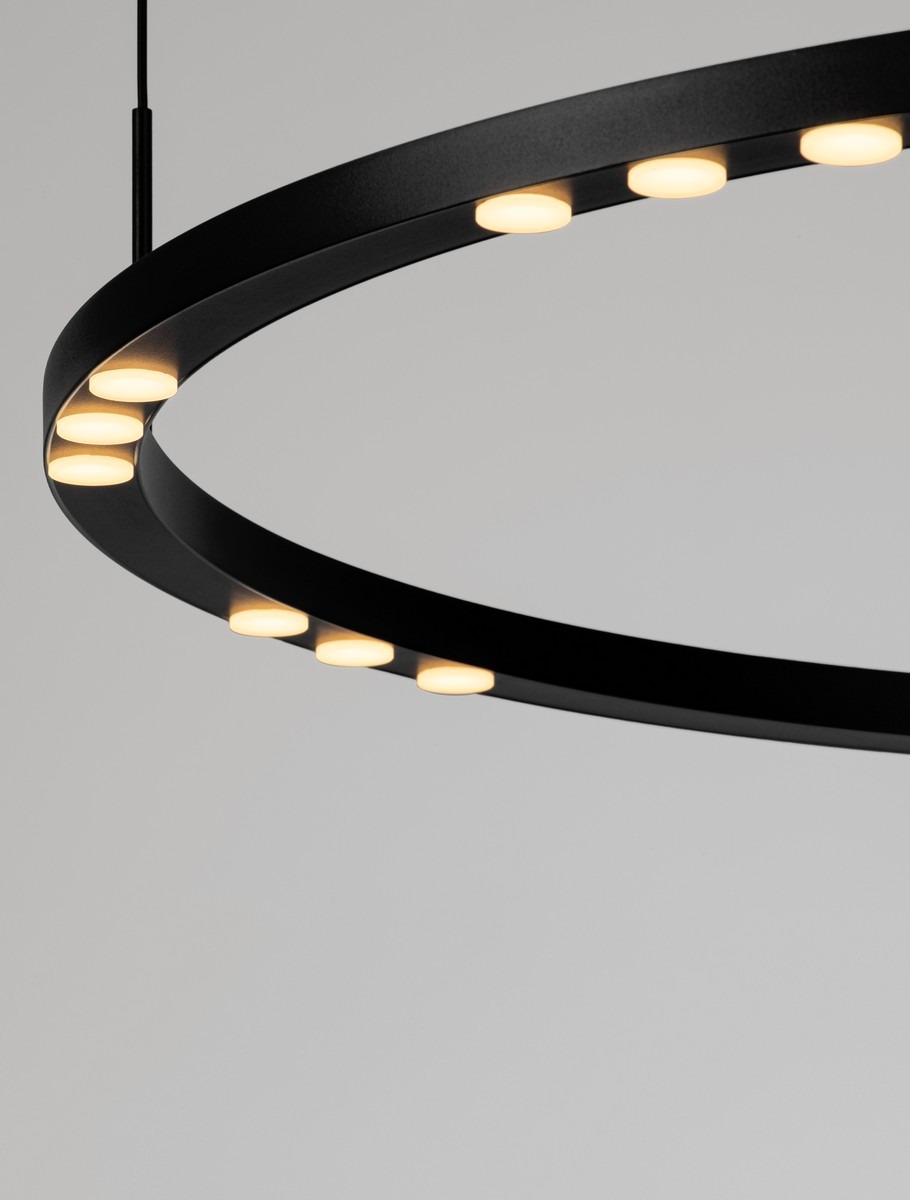 Lampa wisząca Carenso w kolorze czarnym, z metalowym pierścieniem i wbudowanymi diodami LED, zawieszona, z widocznymi okrągłymi źródłami światła. Kąt ujęcia zbliżony, ukazujący detale konstrukcji.