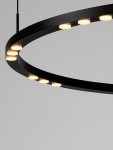 Lampa wisząca Carenso w kolorze czarnym, z metalowym pierścieniem i wbudowanymi diodami LED, zawieszona, z widocznymi okrągłymi źródłami światła. Kąt ujęcia zbliżony, ukazujący detale konstrukcji.