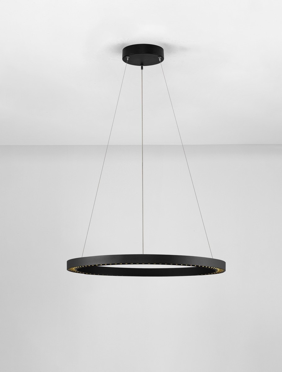 Lampa wisząca Tarvana o średnicy okrągłej, czarnej obudowie, z jedną diodą LED 27W. Zawieszona na cienkich linkach, z widocznym wewnętrznym oświetleniem. Prosta stylistyka, idealna do nowoczesnych wnętrz. Tło w jasnym kolorze.