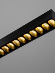 Lampa wisząca Tarvana 1xLED 27W w kolorze czarnym, z ośmioma złotymi reflektorami w kształcie kropli, umieszczona na prostokątnej podstawie. Ujęcie z góry, ukazujące detale oświetlenia. Tło szare, jednolite.