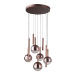 Lampa wisząca LED Camino 54W w kolorze miedzi, składająca się z pięciu okrągłych kul i kilku cylindrycznych elementów. Zawieszona na cienkich linkach, ma okrągłą, metalową podstawę. Temperatura barwowa 3000K zapewnia ciepłe światło.
