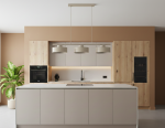 Beżowa lampa wisząca Selia z trzema kloszami E27, zamontowana nad wyspą kuchenną w nowoczesnym wnętrzu. Lampa ma minimalistyczny design, zawieszona na cienkim stelażu. W tle widoczne meble w jasnych odcieniach oraz roślina doniczkowa.