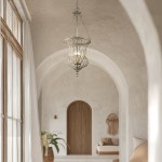 Lampa wisząca Calla M w postarzanym złocie, z trzema oprawami E14. Otwarta klosz w kształcie koszyczka, zawieszona na cienkim łańcuchu. Umieszczona w przestronnym wnętrzu z naturalnym światłem i architektonicznymi łukami w tle.